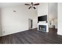 Spacious living room with vaulted ceilings, dark laminate flooring, and a cozy fireplace at 6595 Lancelot Ct, Riverdale, GA 30296