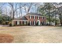 Traditional brick home featuring a manicured lawn and symmetrical design elements at 2947 Margaret Mitchell Nw Ct, Atlanta, GA 30327