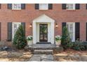 Elegant front entrance with a decorative door, lantern sconces, and manicured greenery at 2947 Margaret Mitchell Nw Ct, Atlanta, GA 30327