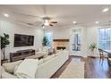 Cozy living room with a stone fireplace, large windows, and hardwood floors at 5022 Towneship Creek Rd, Roswell, GA 30075