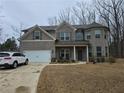 Charming two-story home boasts a brick facade, two-car garage, and well-maintained landscaping in a wooded location at 1001 Brading Pl, Lawrenceville, GA 30043