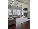 Cozy living room featuring a stone fireplace, coffered ceilings, and hardwood floors at 1001 Brading Pl, Lawrenceville, GA 30043
