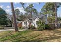 Quaint white home featuring a striking red door, complemented by the lush greenery of the surrounding landscape at 1784 Terry Mill Se Rd, Atlanta, GA 30316