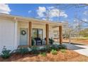 Inviting front porch with seating area, a wreath on the door, and a covered carport at 5450 Frazer Rd, Buford, GA 30518