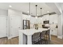 Modern kitchen with white cabinets, quartz countertops, stainless steel appliances, and an island with seating at 1977 Granite Hills Rd, Atlanta, GA 30318