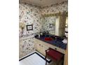 Cozy bathroom with vibrant floral wallpaper, red sink, and tiled countertop at 217 Shields Rd, Stockbridge, GA 30281