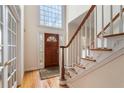 Bright foyer with hardwood floors, staircase and tall window at 755 Creek Wind Ct, Johns Creek, GA 30097