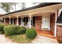 Inviting brick porch with rocking chairs and classic white columns at 1728 Stonecliff Ct, Decatur, GA 30033