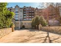 Wide exterior shot of a condo building surrounded by lush greenery and mature trees at 3280 Stillhouse Se Ln # 108, Atlanta, GA 30339