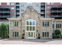 Beautiful exterior shot of a condo building showcasing the stone facade, windows, and landscaping at 3280 Stillhouse Se Ln # 108, Atlanta, GA 30339