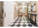 Inviting entryway featuring black and white tile flooring, a console table, and a view into the living room at 3280 Stillhouse Se Ln # 108, Atlanta, GA 30339