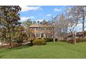 Traditional two-story home with a manicured lawn and mature trees on a sunny day at 4481 Windsor Oaks Dr, Marietta, GA 30066