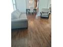 Inviting living room featuring hardwood floors, a comfortable sofa, and a view into the dining area at 818 Burchill Sw St, Atlanta, GA 30310