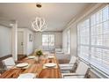 Staged dining room featuring hardwood floors, modern lighting fixture, table and large windows at 275 Carriage Chase, Fayetteville, GA 30214