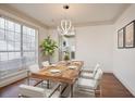 Bright dining room features hardwood floors, table set and large windows, connecting to the kitchen at 275 Carriage Chase, Fayetteville, GA 30214