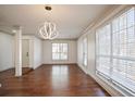 Bright dining room featuring hardwood floors, modern lighting fixture, and large windows at 275 Carriage Chase, Fayetteville, GA 30214