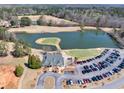 Aerial view of a beautiful community clubhouse, a scenic pond, and a parking lot in a quiet neighborhood at 49 Inverness Ct, Hiram, GA 30141