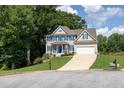 Charming two-story home with blue shutters, white trim and a well-manicured lawn on a sunny day at 49 Inverness Ct, Hiram, GA 30141
