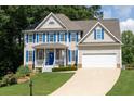 Charming two-story home with blue shutters, white trim, inviting porch, and well-manicured lawn at 49 Inverness Ct, Hiram, GA 30141