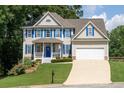 Charming two-story home with blue shutters, white trim, inviting porch, and well-manicured lawn at 49 Inverness Ct, Hiram, GA 30141