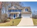 Inviting two-story home with blue shutters, lush lawn, and an attached two-car garage at 49 Inverness Ct, Hiram, GA 30141