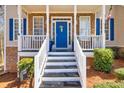 Welcoming front porch with white railings, stone accents, and a bright blue front door at 49 Inverness Ct, Hiram, GA 30141