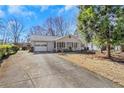 Inviting single-story home with a covered front porch, attached garage, and well-maintained lawn, exuding curb appeal at 1006 Walnut Dr, Lawrenceville, GA 30044