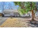 Well-maintained home featuring a covered porch, garage, and landscaped yard, shaded by a large tree at 1006 Walnut Dr, Lawrenceville, GA 30044