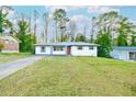 Charming one-story home featuring white brick, a long driveway, and a well-manicured lawn at 1877 Glenmar Dr, Decatur, GA 30032