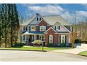 Charming two-story home with a brick and gray exterior, lush lawn, and manicured landscaping creates excellent curb appeal at 203 Glenrise Ct, Woodstock, GA 30188