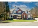 Charming two-story home with a brick and gray exterior, lush lawn, and manicured landscaping creates excellent curb appeal at 203 Glenrise Ct, Woodstock, GA 30188