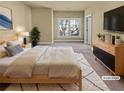 Light and airy main bedroom featuring a plush rug, tv, large window, and ensuite bath at 3628 Princeton Ave, Atlanta, GA 30337