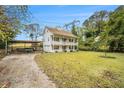 Two-story house with a double front porch and a long driveway leading to a carport at 4141 Willow Ridge Rd, Douglasville, GA 30135