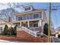Gray two-story home with a welcoming front porch, white railings, and brick accents along the front walkway at 303 Bass Se St, Atlanta, GA 30315