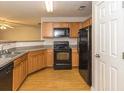 Well-lit kitchen featuring light wood cabinets, grey countertops, and black appliances at 5171 Hanover St, Atlanta, GA 30349