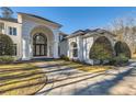 Grand home exterior featuring a circular driveway, manicured lawn, and architectural details at 490 Birkdale Dr, Fayetteville, GA 30215