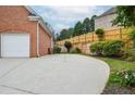Spacious driveway leading to garage with backyard area featuring wooden fence for added privacy at 11385 Donnington Dr, Duluth, GA 30097