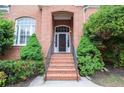 Inviting front entrance with brick steps and railing, surrounded by lush landscaping at 11385 Donnington Dr, Duluth, GA 30097