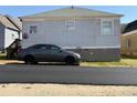 Rear view of house with gray car parked nearby at 23 Poplar St, Porterdale, GA 30014