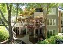 Multi-story condo building surrounded by mature trees and landscaping with private outdoor living areas at 402 Bainbridge Dr, Atlanta, GA 30327