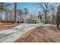 Landscaped yard, long drive, and mature trees surround this charming home's exterior at 596 Frank Kirk Nw Rd, Kennesaw, GA 30152