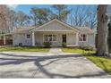 Charming single-story home featuring a covered front porch, lush landscaping, and a well-manicured lawn at 596 Frank Kirk Nw Rd, Kennesaw, GA 30152