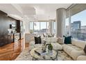 Sunlit living room with modern furnishings, open to a kitchen with stainless steel appliances and city views at 1080 Peachtree Ne St # 2011, Atlanta, GA 30309