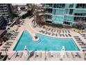 Resort-style condo pool deck with ample lounge chairs, inviting blue water, and sunny patio at 1080 Peachtree Ne St # 2011, Atlanta, GA 30309