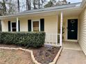 Inviting home exterior featuring a green door with wreath and manicured landscaping at , Kennesaw, GA 30152