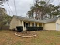 Ranch style home with light yellow siding, dark shutters, and manicured front landscaping at , Kennesaw, GA 30152