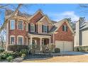 Charming two-story home with brick exterior, arched windows, and a manicured front lawn at 1654 Summersweet Ln, Dacula, GA 30019