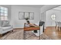 Bright home office featuring neutral decor, hardwood floors, and a comfortable chair by a window at 1654 Summersweet Ln, Dacula, GA 30019