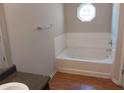 Bathroom with a bathtub and tile surround, complemented by a window and vanity at 5175 Hanover St, Atlanta, GA 30349