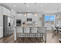 Beautiful kitchen featuring stainless steel appliances, a large center island with seating, and sleek white cabinetry at 7630 Rambling Vale, Cumming, GA 30028